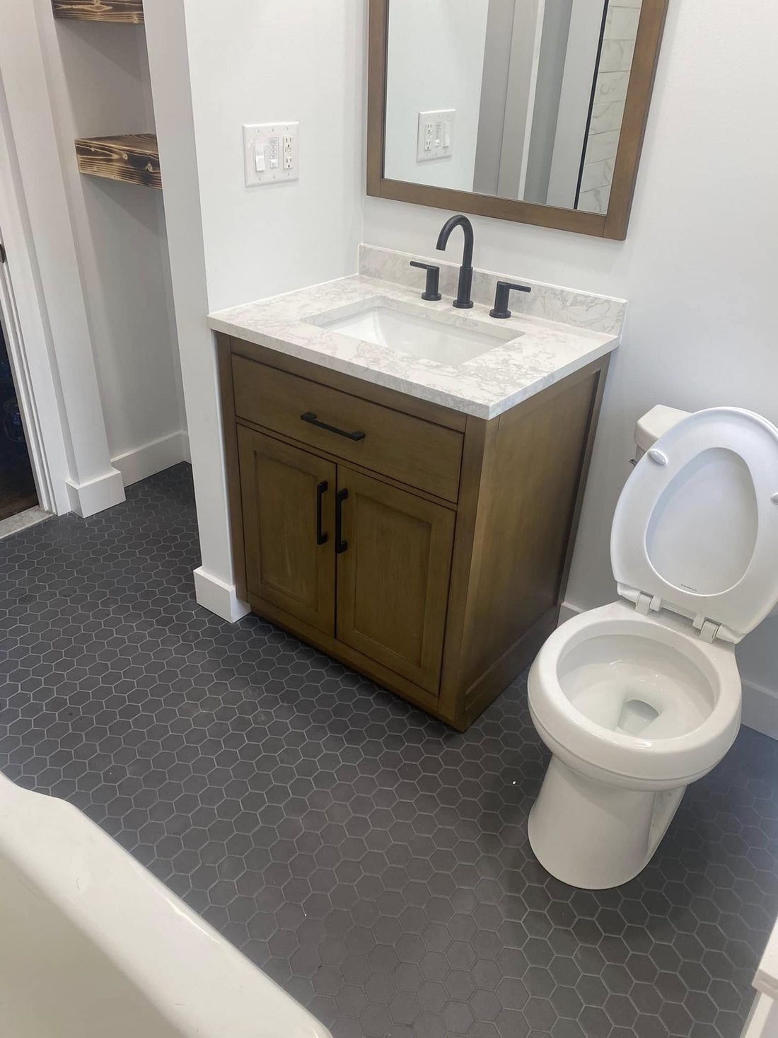 Bathroom renovation with wood vanity and hexagon tile floor