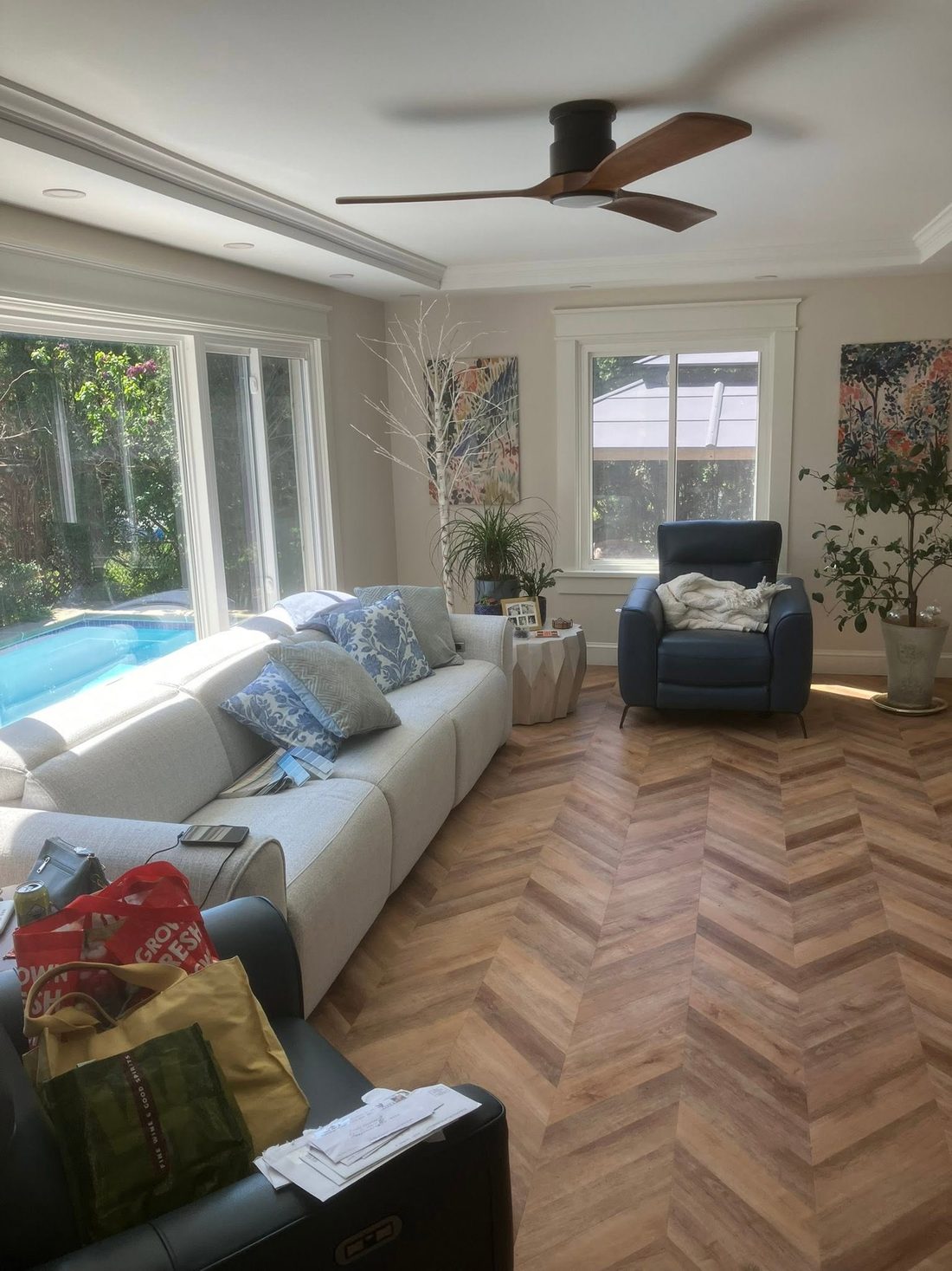 Four-season room with herringbone floors and sliders to the pool